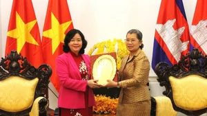 Bui Thi Minh Hoai (L), Politburo member, Secretary of the Communist Party of Viet Nam (CPV) Central Committee and President of the Viet Nam Fatherland Front (VFF) Central Committee, presents a souvenir to Men Sam An, Vice President of the Cambodian People's Party (CPP) and President of the National Council of the Solidarity Front for the Development of Cambodia Motherland (SFDCM), in Phnom Penh on February 6. (Photo: VNA)