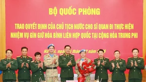 Officials at the ceremony presenting the decisions to Lieutenant Colonel Nguyen Hoang Long (fourth from right), who will serve at the UN Multidimensional Integrated Stabilisation Mission in the Central African Republic (MINUSCA) (Photo: VNA)