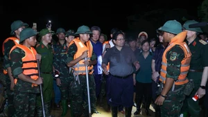Prime Minister Pham Minh Chinh visits the forces working to reinforce the Cau River embankment, emphasising the need to ensure the dike’s safety. (Photo: NDO)