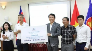 A representative of the Viet Nam–Cambodia Business Association (VCBA) presents its donated fund to the leaders of the Vietnamese Ambassador to Cambodia Nguyen Minh Vu (2nd from left). (Photo: VNA)