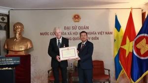 Ambassador Tran Van Tuan (R) presents the “For the Cause of Culture, Sports and Tourism” insignia to Swedish filmmaker Bo Öhlén. (Source: Embassy of Viet Nam in Sweden)
