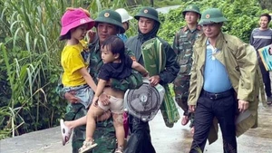 Border guards at Ba Nang Border Guard Station, Quang Tri Province, help children move to safety. (Photo: VNA)