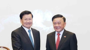 Politburo member and standing member of the Party Central Committee’s Secretariat Tran Cam Tu (R) bids farewell to Lao Party General Secretary and President Thongloun Sisoulith. (Photo: VNA)