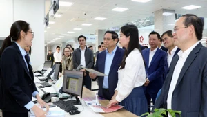 Prime Minister Pham Minh Chinh (in blue shirt) visits the Quang Ninh Public Administration Service Centre (Photo: VNA)