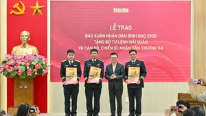Editor in Chief of Nhan Dan Newspaper Le Quoc Minh presents Tet newspapers to representatives of the recipients. (Photo: NDO)