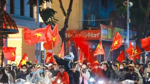 Residents in Ha Noi celebrate the Vietnamese U22 team's win at the 33rd SEA Games on December 18 evening. (Photo: VNA)