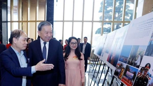 Party General Secretary To Lam visits a photo exhibition held by Viet Nam News Agency on the sidelines of the national conference on December 19. (Photo: VNA)