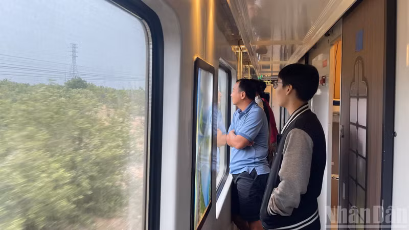 Passengers enjoy the scenery through the carriage windows.