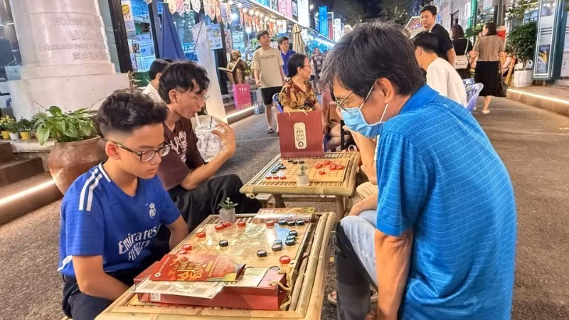 Residents try out traditional folk games at the festival. (Photo: VNA)