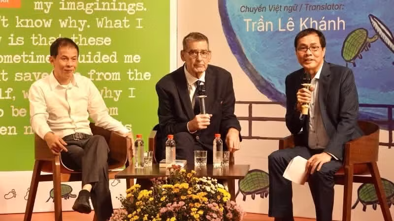 American poet Bruce Weigl (centre), translator Tran Le Khanh (left), and poet Huu Viet talks with readers at the book launch and art exhibition in Ha Noi on June 2. (Photo: nhandan.vn)
