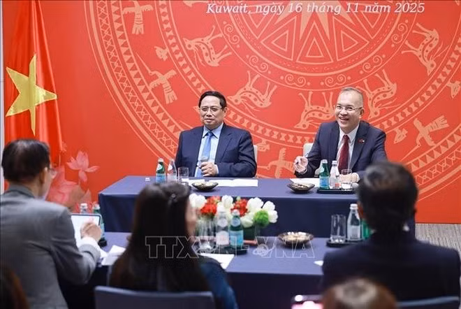 Prime Minister Pham Minh Chinh (left) meets with staff of Vietnamese representative offices and the Vietnamese community in Kuwait on the evening of November 16. (Photo: VNA)
