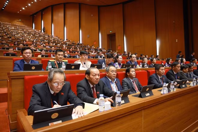 Delegates discuss the Congress's documents at the hall. (Photo: VNA)