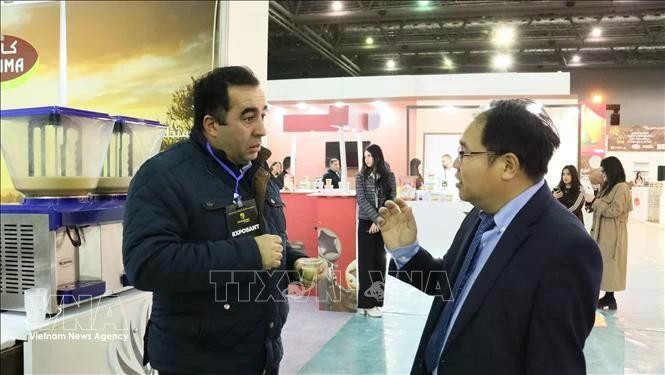Hoang Duc Nhuan – Trade Counselor of Viet Nam in Algeria, discusses with a representative of an Algerian company exporting carbob powder to Viet Nam (Photo: VNA)