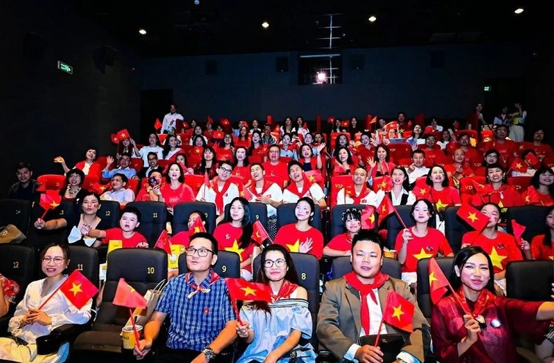 Audiences dressed in red shirts adorned with yellow stars – a tribute to the national flag – gather for the premiere of the film ‘To quoc trong tim: The concert film’ yesterday in Ha Noi. (Photo: VNA)