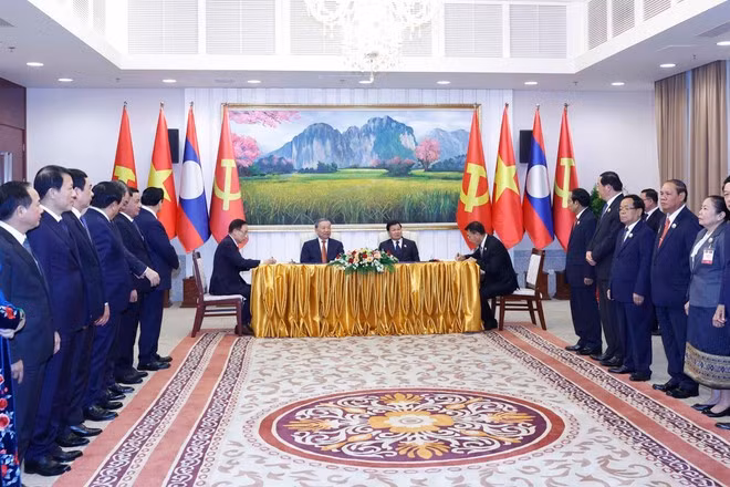 General Secretary of the Communist Party of Viet Nam Central Committee To Lam (second, left) and General Secretary of the Lao People's Revolutionary Party Central Committee and President of Laos Thongloun Sisoulith witness the signing of an agreement between the two Parties' Politburo. (Photo: VNA)