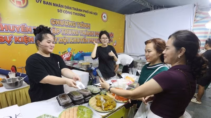 Consumers experience cashless payment methods at the event. (Photo: nhandan.vn)