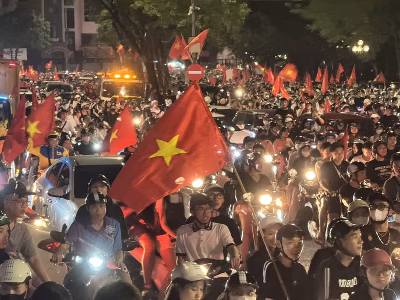 People take to Hanoi streets waving the national flag in celebration of the victory. (Photo: VNA)