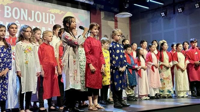 Vietnamese and French children perform the song "Bonjour Viet Nam" at the festival. (Photo: VNA)