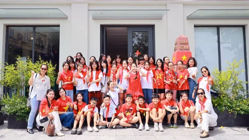 Students take souvenir photos at the Truong Sa sovereignty marker model at Ho Guom Cultural Information Centre. (Photo: nhandan.vn)