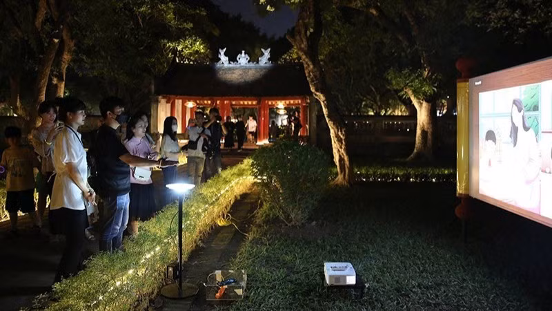 Visitors take part in the “Temple of Literature – Quoc Tu Giam” night experience tour. (Photo: THANH NGUYEN)
