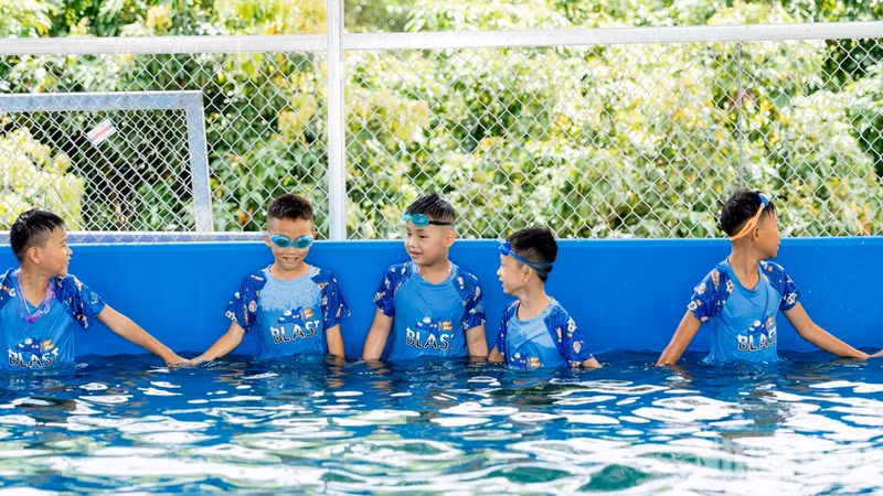 Students of Dong Vuong Primary School experience a swimming lesson shortly after the swimming pool is inaugurated.