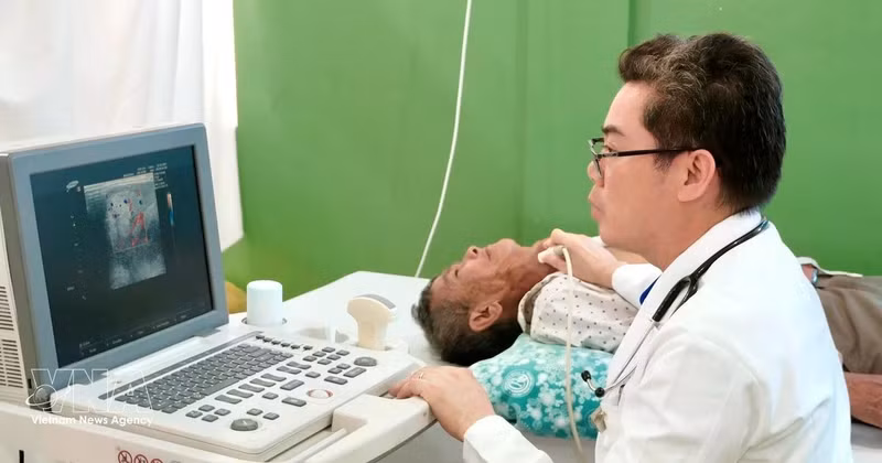 Dr Ton Thanh Tra, Director of Cho Ray–Phnom Penh Hospital, personally examines and performs an ultrasound for a critically ill patient, who was later admitted for free surgery at the hospital. (Photo: VNA)