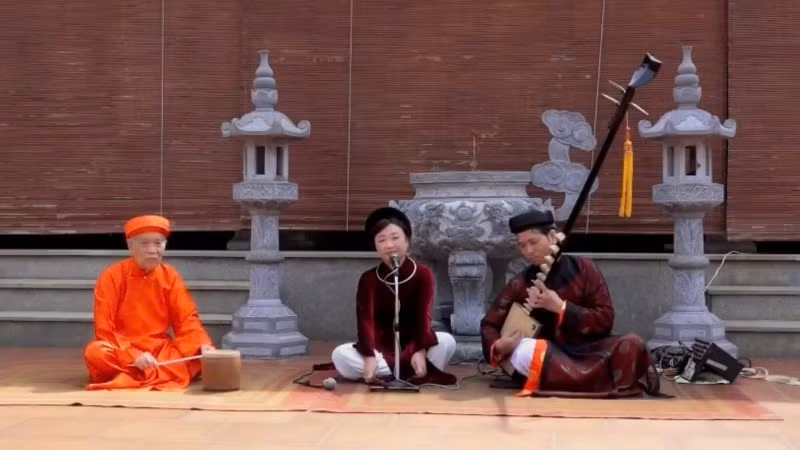 Meritorious Artisan Phuong Hong (centre) performing ca tru at Dac So communal house, Ha Noi. (Photo courtesy of the character)