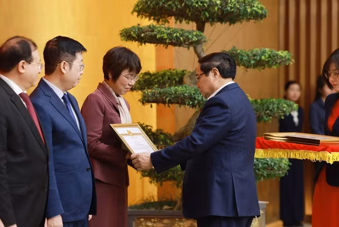 Prime Minister Pham Minh Chinh presents Certificate of merit from the Government’s Party Committee to General Director of the Viet Nam News Agency Vu Viet Trang. (Photo: VNA)