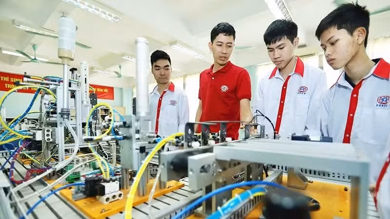 Students in an industrial electronics class practise on an automation model at Ha Noi High-Tech Vocational College.