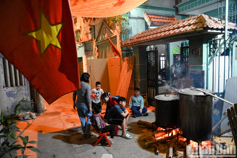 Ms Tuyen’s extended family gathers together to watch over the pot of banh chung in a small alley on Vu Tong Phan Street. Ms Tuyen’s extended family gathers together to watch over the pot of banh chung in a small alley on Vu Tong Phan Street.