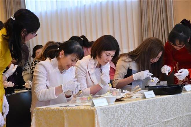 Guests, including Princess Takamado and the wife of the Japanese Prime Minister, have the opportunity to create 3D jelly flowers under the guidance of Vietnamese artisan Tran Phuong Nga. (Photo: VNA)