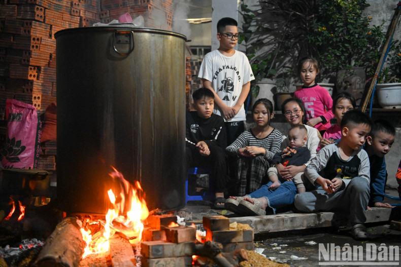 In a corner of the yard in alley 342 Khuong Dinh (Thanh Xuan District), Ms Hong Tam and her family of three generations of children and grandchildren stayed up to watch over the pot of banh chung. In a corner of the yard in alley 342 Khuong Dinh (Thanh Xuan District), Ms Hong Tam and her family of three generations of children and grandchildren stayed up to watch over the pot of banh chung.