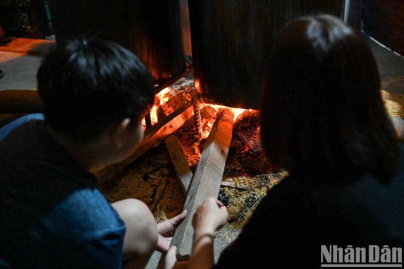 The children are taught how to boil the cakes by adults, while the whole family watch over the pot of banh chung. The children are taught how to boil the cakes by adults, while the whole family watch over the pot of banh chung.