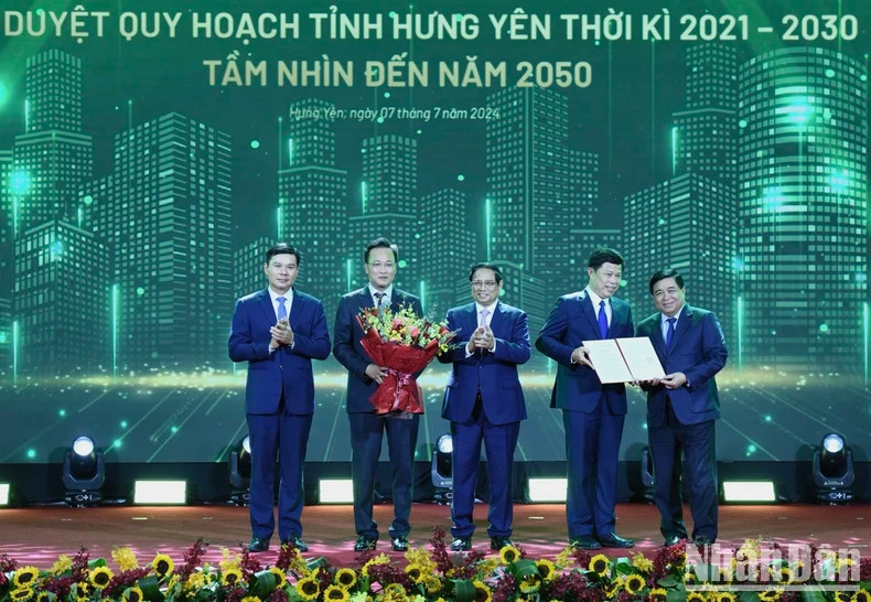 Prime Minister Pham Minh Chinh (C) and Minister of Planning and Investment Nguyen Chi Dung (first, R) present the decision approving Hung Yen's master plan to leaders of Hung Yen.