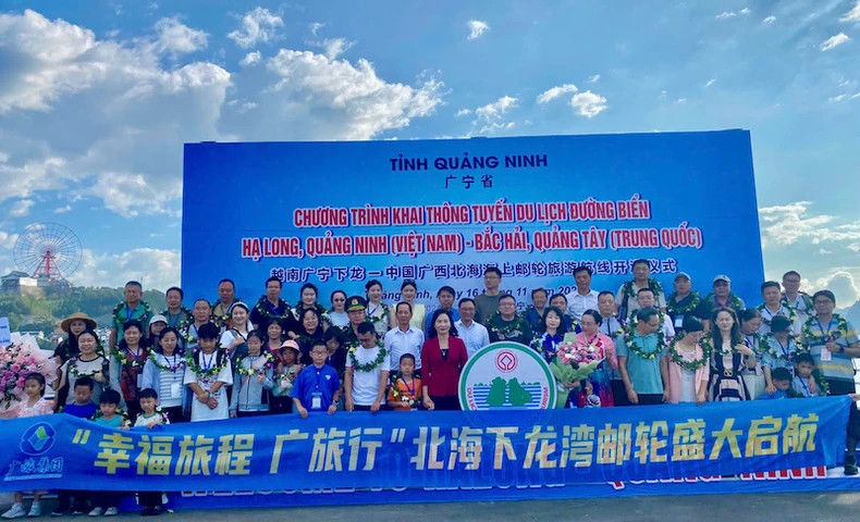 Leaders of Quang Ninh Province and the Department of Tourism take souvenir photos with tourists.