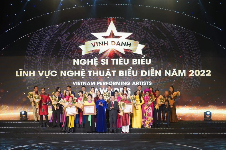 Editor-in-Chief of Nhan Dan Newspaper Le Quoc Minh and Secretary of the Ha Nam Provincial Party Committee Le Thi Thuy honour outstanding artists at the programme.
