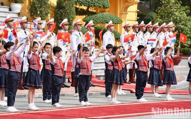 Children wave to welcome the two PMs.