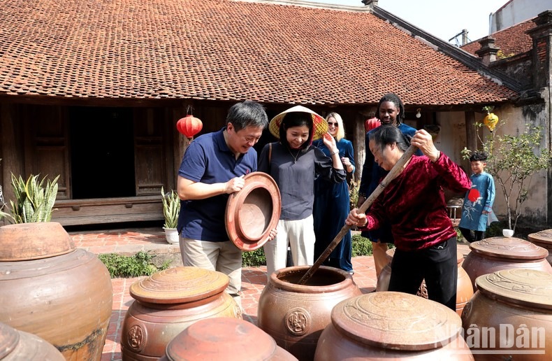 Visitors learn about the traditional craft of making soy sauce in Duong Lam village. Visitors learn about the traditional craft of making soy sauce in Duong Lam village.