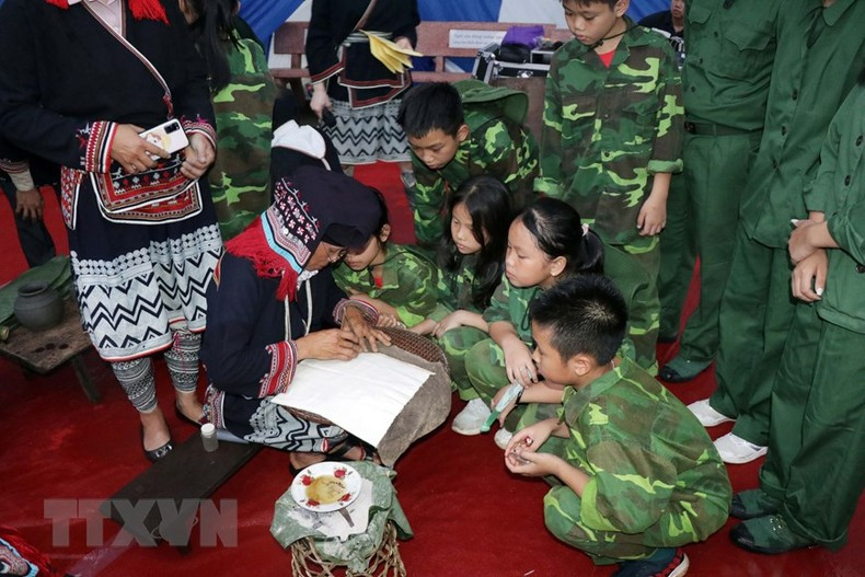 Performing activities of cultural features of the Dao people attracted a large number of children to learn. (Photo: Huu Quyet/VNA)