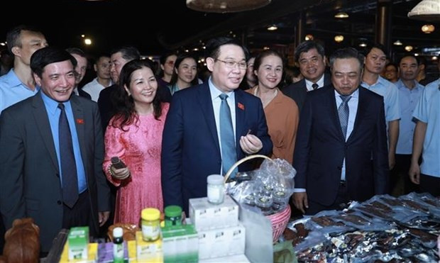 NA Chairman Vuong Dinh Hue (centre) visits booths display OCOP products at the Vietnam Craft Villages Festival. (Photo: VNA)