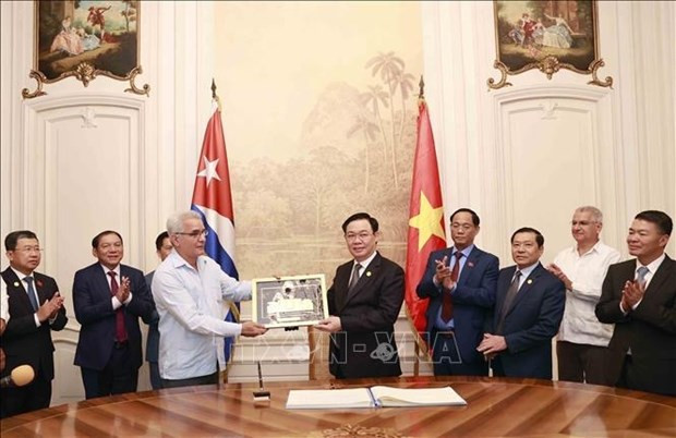 NA Chairman Vuong Dinh Hue gives present to the centre. (Photo: VNA)