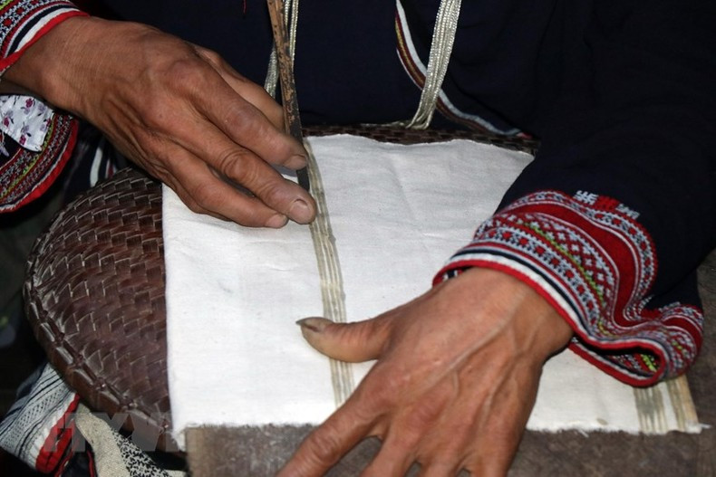 Patterned products are printed with beeswax by Dao artisans. (Photo: Huu Quyet/VNA)