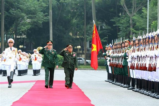Gen. Luong Cuong, Chairman of the VPA’s General Department of Politics, and Sen. Lieut. Gen. Thongloi Silivong inspect the guard of honour. (Photo: VNA)