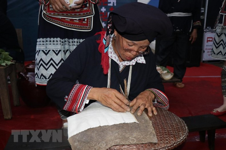 Dao artists perform printing patterns with beeswax. (Photo: Huu Quyet/VNA)