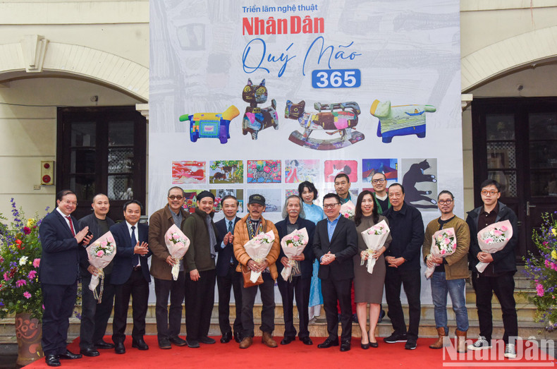 Leaders of Nhan Dan Newspaper present flowers to artists participating in the project.