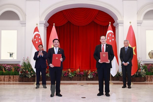 Prime Minister Pham Minh Chinh and his Singaporean counterpart Lee Hsien Loong witness the signing of a Memorandum of Understanding between the Ministry of Industry and Trade of Vietnam and the Ministry of Industry and Trade of Singapore. (Photo: VNA)
