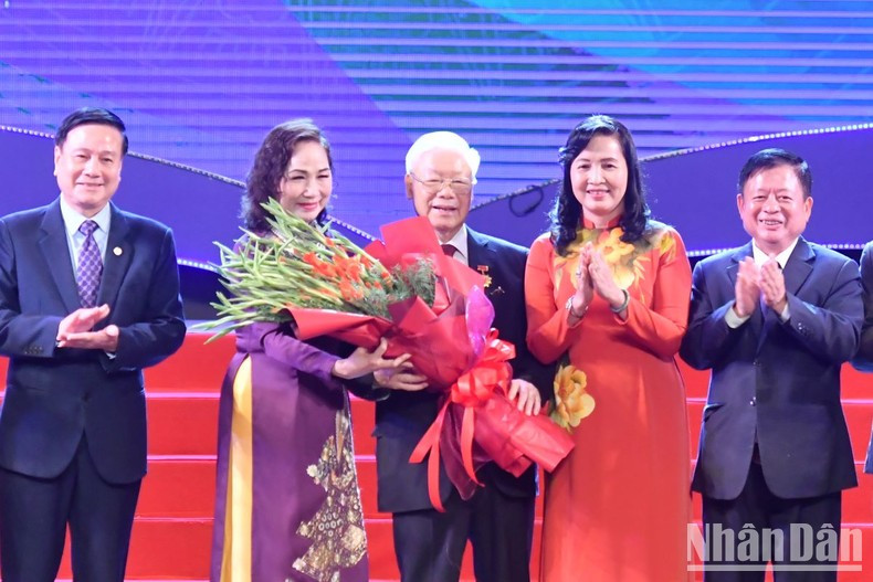 Leaders of the Alliance of Arts and Literature Associations of Vietnam present flowers and the insignia “For the cause of literature and arts of Vietnam” to Party General Secretary Nguyen Phu Trong.