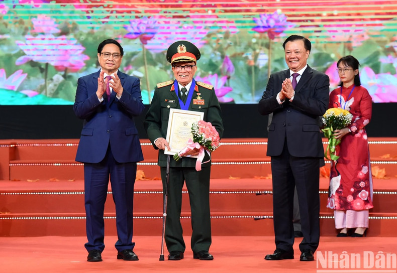 Prime Minister Pham Minh Chinh and Secretary of the Hanoi Party Committee Dinh Tien Dung present the “Outstanding Citizen of the Capital” title to Lieutenant General, Hero of the People's Armed Forces Khuat Duy Tien - member of the Veterans Association in Dien Bien ward, Ba Dinh district.