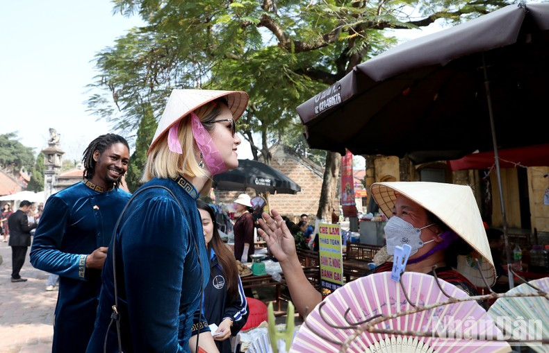 Hyomi from the US brings herself a conical hat at the country market. Hyomi from the US brings herself a conical hat at the country market.