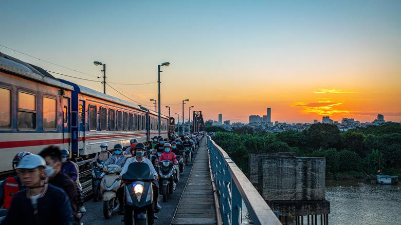 A train crosses the bridge in Hanoi during rush hour. A train crosses the bridge in Hanoi during rush hour.